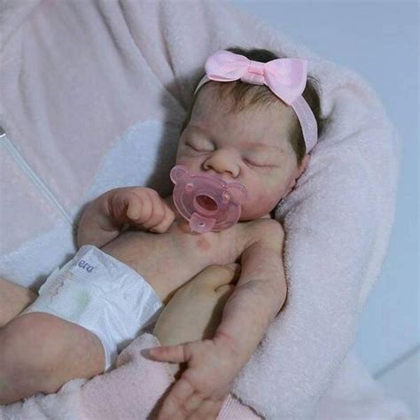A Newborn Baby Wearing A Pink Pacifier In Her Mouth And Wrapped In A Blanket