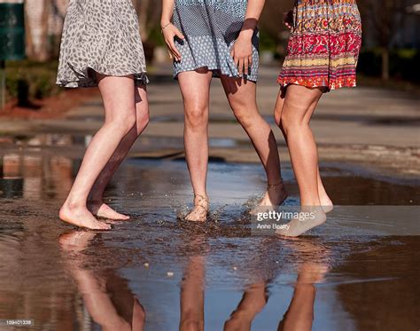 Barefoot Girls Splashing In Puddle Photo Getty Images