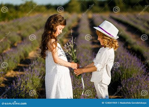 A Boy Giving Lavender Flowers To The Girl At Sunset In The Lavender