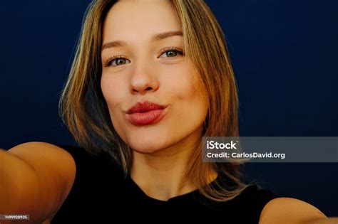 Young Beautiful Woman Blows Kiss At Camera Takes Selfie Portrait Stock