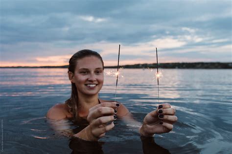 Beautiful Woman In A Lake Holding Sparklers By Stocksy Contributor Carey Shaw Stocksy