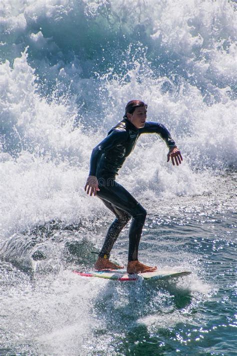 Closeup Of Surfer In A Wet Suit Balancing On His Surf Board While