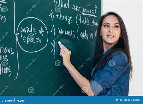 Teacher Writing On Blackboard Schoolteacher Explaining Lesson In Classroom Royalty Free Stock