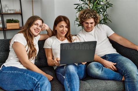 Mother And Couple Using Laptop Sitting On Sofa At Home Stock Image