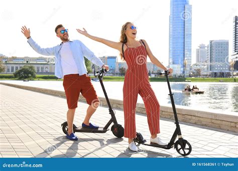 Lovely Couple Having Fun Driving Electric Scooter Along The City Promenade Stock Image Image