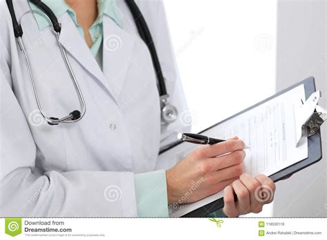 Female Doctor Filling Up Medical Form On Clipboard Closeup Healthcare