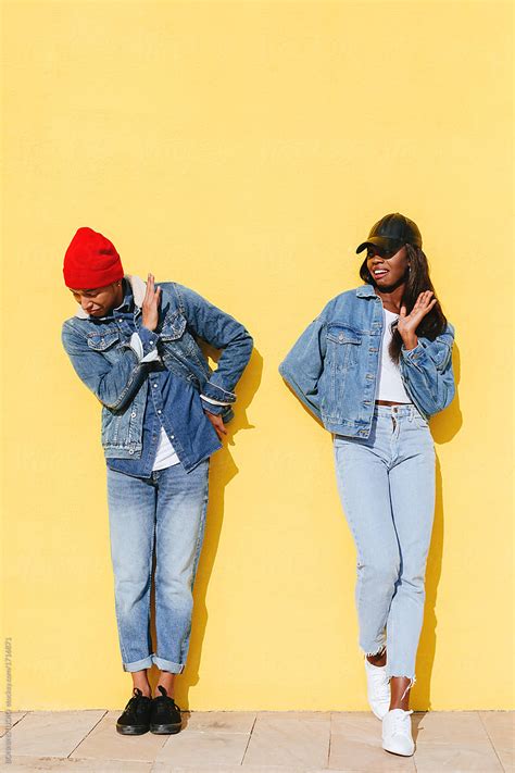 Funny Cool Couple Wearing Denim Clothes In Yellow Wall By Stocksy