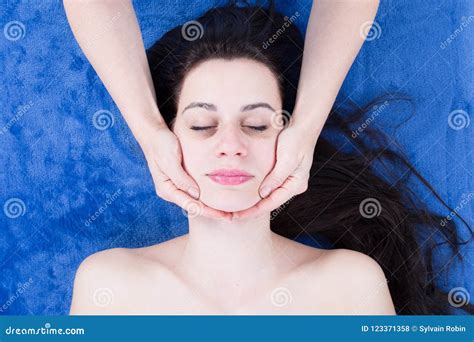 Young Woman Have Face Massage By Beautician In Spa Center Stock Photo