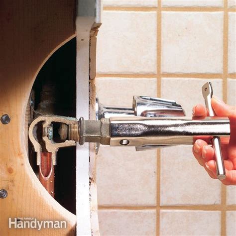 Insert a flathead screwdriver into the faucet body and behind the diverter. How To Repair a Leaking Tub Faucet | The Family Handyman