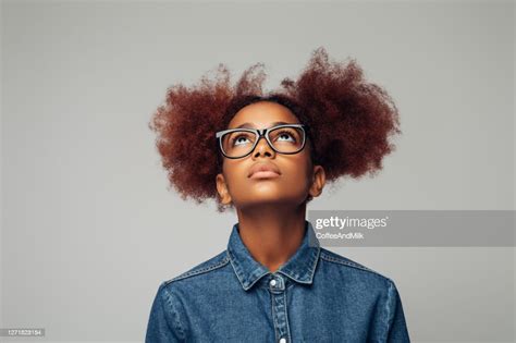 Photo Of Young Curly Girl With Glasses Looking Up High Res Stock Photo