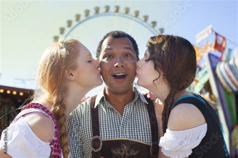 Young Man Getting Kissed On The Cheek By Two German Girls At