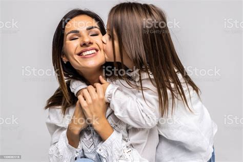 Portrait Of Daughter Kissing Her Mother Isolated On White Background