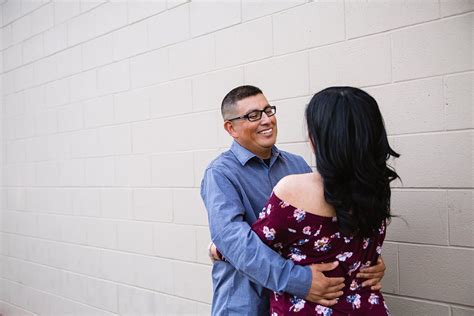 Couple Looking At Each Other Against Brick Wall During Their Engagement