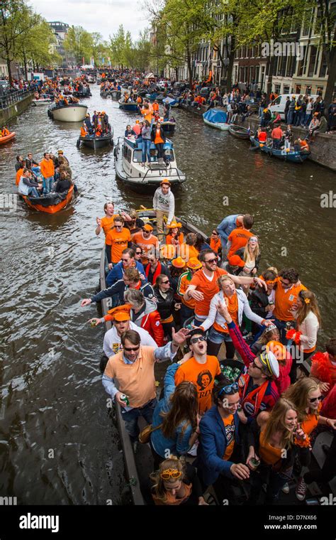 annual queens day in the netherlands boat parade in the canals of amsterdam old town people