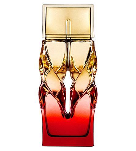 The Perfume Bottle Is Red And Gold With An Artistic Design On It S Side