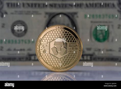 Cronos Cro Cryptocurrency Physical Coin Placed On Reflective Surface And Dollar Bill In The
