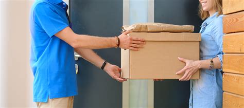 Smiling Delivery Man In Blue Uniform Delivering Parcel Box To Recipient