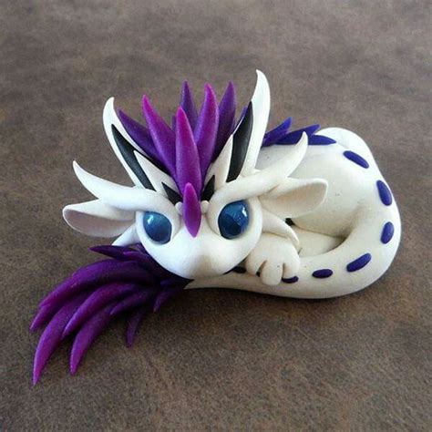 A White And Purple Dragon Figurine Laying On The Ground