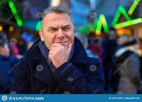 Thoughtful Man With Hand To Chin Standing Frowning Stock Image Image