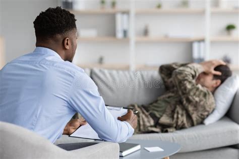 Upset Guy Soldier Laying On Couch While Therapy Session Crying Stock