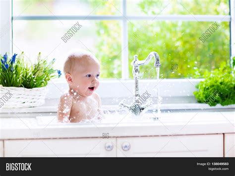 Position the bath somewhere stable and at a height where you can comfortably hold your baby. Baby Taking Bath Kitchen Sink. Image & Photo | Bigstock