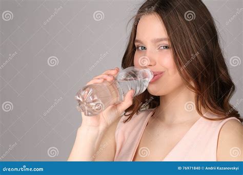 Model In Pink Top Drinking Water Close Up Gray Background Stock Photo