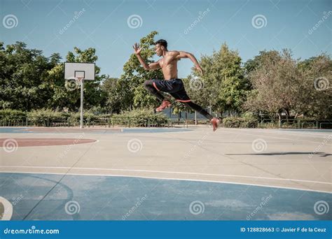 Afroamerican Young Man Jumping On A Basketball Court Stock Image