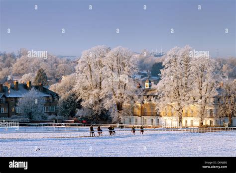 Riders And Horses On Newmarket Heath In The Winter Snow At Sunrise