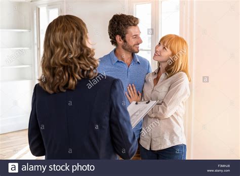 Real Estate Agent Showing Modern White Apartment To Future Owners
