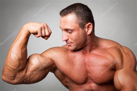Hombre Musculoso Flexionando Sus Bíceps Fotografía De Stock
