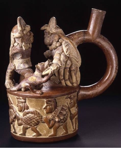a moche stirrup spout vessel with a molded relief body and a top decorated with a sculpted scene
