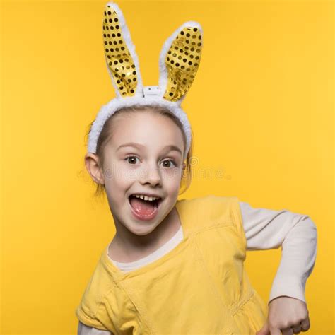 Smiling Little Girl With Bunny Ears On The Yellow Background Stock