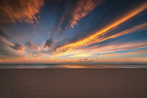 Colorful Ocean Beach Sunrise With Deep Blue Sky And Sun Rays Stock