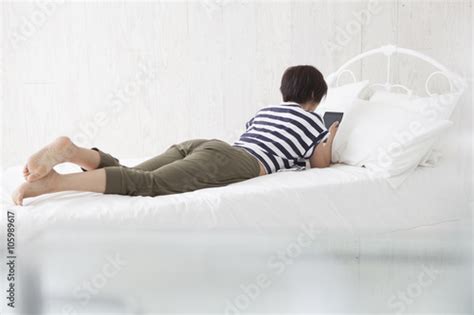 Women Are Looking At The Tablet Lying Face Down In Bed 이 스톡 사진 구입 및