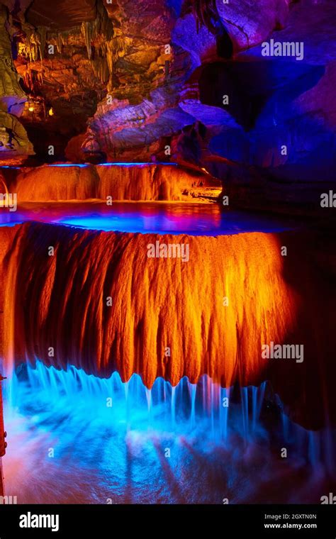 Waterfalls In Underground Cave Flowing Over Rock Formations With Orange