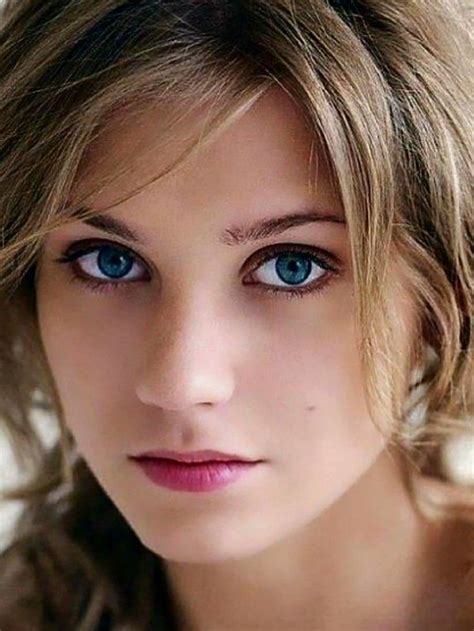 A Close Up Of A Person With Blue Eyes And Blonde Hair Looking At The Camera