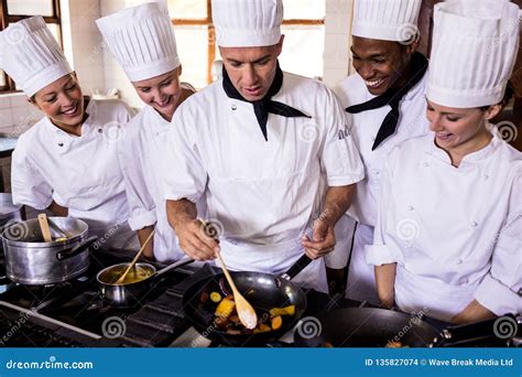 Group Of Chefs Preparing Food In Kitchen Stock Photo Image Of Adult