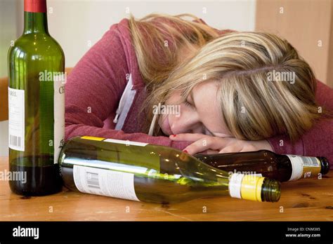 Young Blonde Alcoholic Woman Drunk With Empty Bottles Of Alcohol Uk