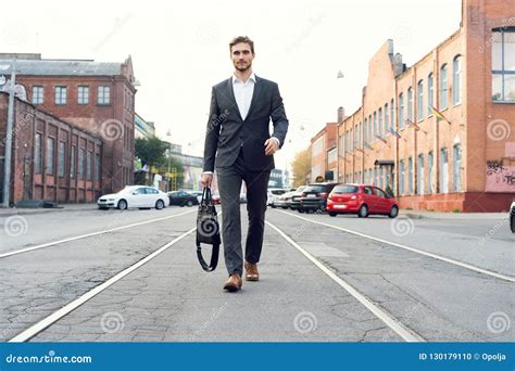 A Handsome Young Businessman Walking On The Street In The Sunset Stock