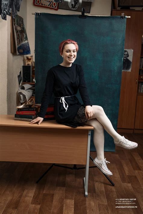 A Woman Sitting On Top Of A Wooden Desk