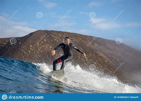Surfer Riding Waves On The Island Of Fuerteventura In The Atlantic