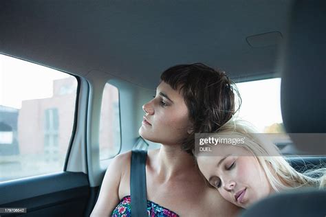 Women In Backseat Of Car One With Head On Friends Shoulder High Res