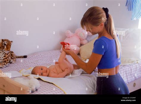 Mother Changing Babies Diaper At Home On Bed Stock Photo Alamy
