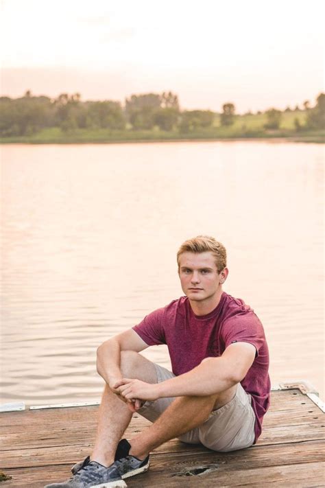 Senior Guy Sitting Pose By The Lake At Sunset Senior Photos Guy