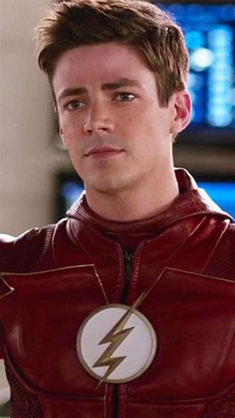 The Flash Standing In Front Of A Tv Screen With His Hand On His Hip And Looking At The Camera