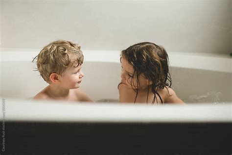 brother and sister talking during bath time stock image everypixel