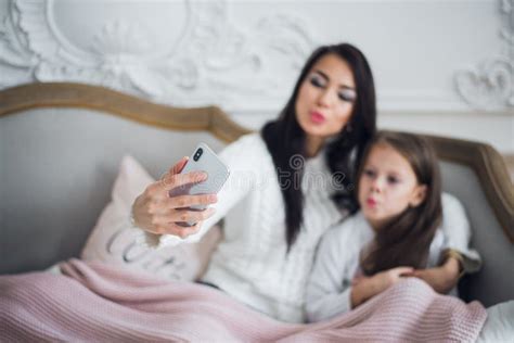 Happy Mother And Daughter Taking Funny Christmas Selfies At Home Stock