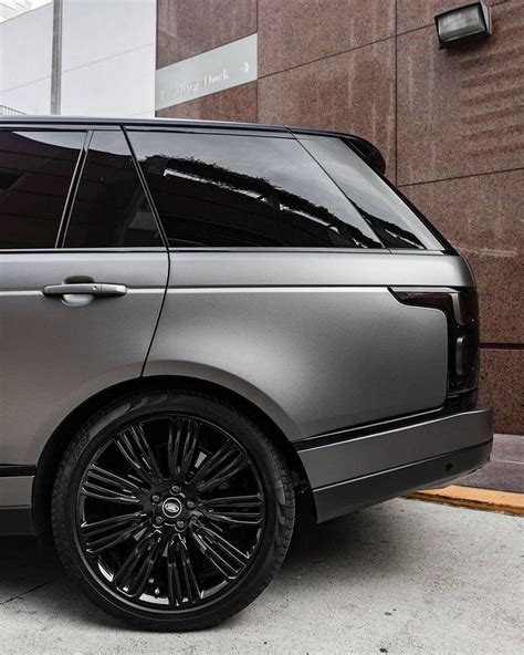 A Silver Range Rover Parked In Front Of A Brick Building With Black