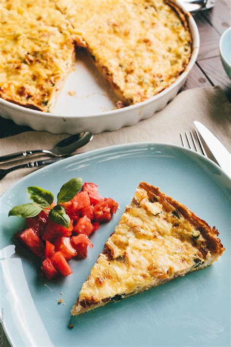 Slice Of Quiche Garnished With Tomatoes By Stocksy Contributor