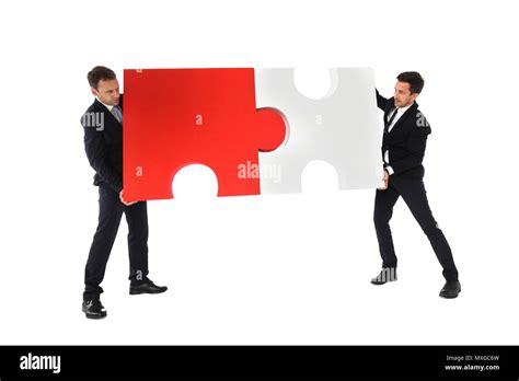 Business Men Holding Two Puzzle Pieces To Connect Isolated On White